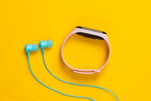 Earphones Smart Bracelet Yellow Background Modern Gadgets Top View — Stock Photo, Image