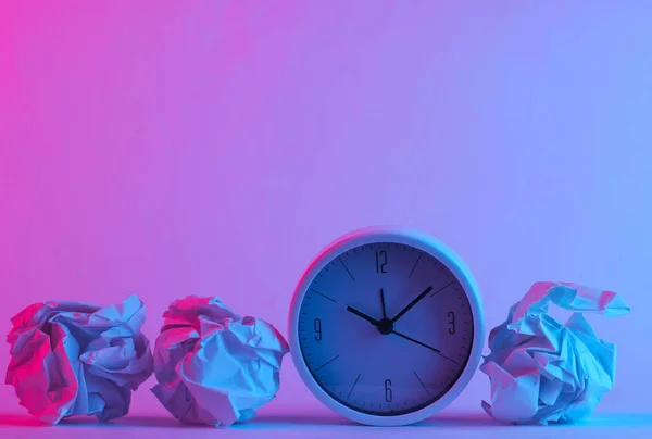时钟与皱折纸球在时髦的霓虹灯下 明亮的粉色蓝色光芒 概念艺术 最低限度主义 — 图库照片