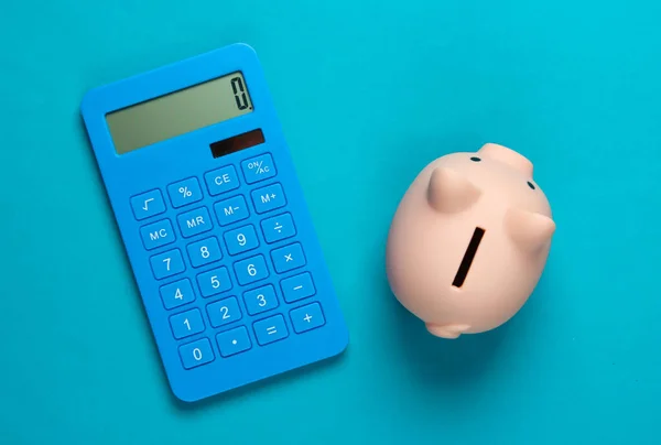 Piggy Banco Calculadora Fundo Azul Tiro Estúdio Minimalista Vista Aérea — Fotografia de Stock