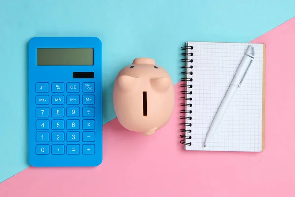 Piggy Bank Notebook Calculadora Fundo Pastel Azul Rosa Tiro Estúdio — Fotografia de Stock