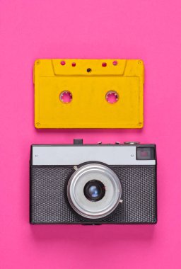 Retro ses kaseti ve pembe arka planda film kamerası. 80 'ler. Üst Manzara. Minimalizm