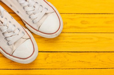 Sarı ahşap arka planda 80 'lerden kalma Retro ayakkabılar. Üst görünüm