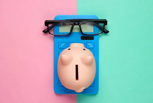 Piggy Bank Och Blå Miniräknare Glasögon Rosa Blå Bakgrund Minimalistisk — Stockfoto