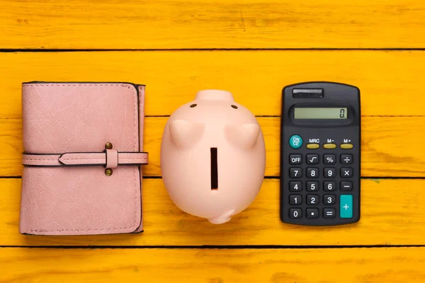 Varkensbank Met Leren Portemonnee Rekenmachine Een Gele Houten Achtergrond Bovenaanzicht — Stockfoto