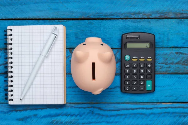 Banco Piggy Com Notebook Calculadora Fundo Madeira Azul Vista Superior — Fotografia de Stock