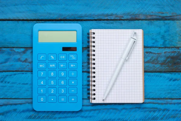 Calculadora Con Cuaderno Sobre Fondo Madera Azul Vista Superior — Foto de Stock