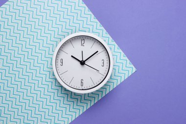 Kağıt arkaplanda beyaz saat. Minimalist stüdyo çekimi. Üst görünüm