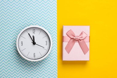 Noel, yeni yıl teması. Sarı mavi arka planda saati olan hediye kutusu. Üst görünüm