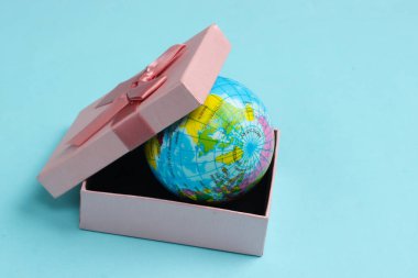 Mavi arka planda bir hediye kutusunda küre.