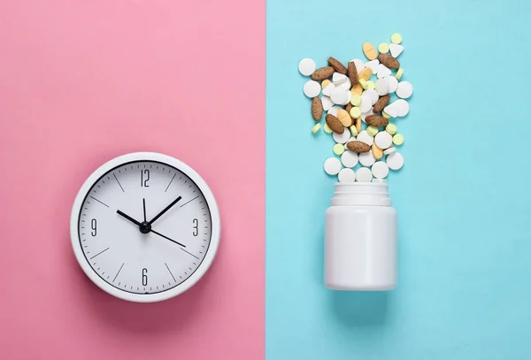 Czas Pigułki Biały Zegar Butelką Tabletek Niebiesko Różowym Pastelowym Tle — Zdjęcie stockowe