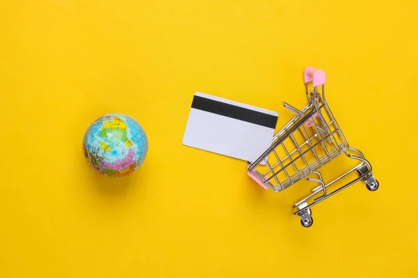 Тема Покупок Тележка Супермаркета Глобусом Кредитка Желтом Фоне Вид Сверху — стоковое фото