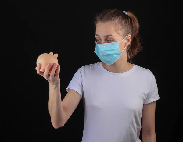 Mulher Uma Máscara Proteção Médica Segurando Banco Porquinho Fundo Preto — Fotografia de Stock