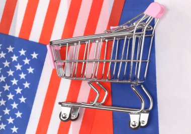 Uluslararası, küresel süpermarket. Bulanık ABD ve Rusya bayrağının arka planında Mini alışveriş arabası. Alışveriş konsepti.