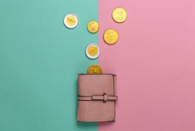 Pembe mavi arka planda bozuk paralar olan deri cüzdan. Üst görünüm