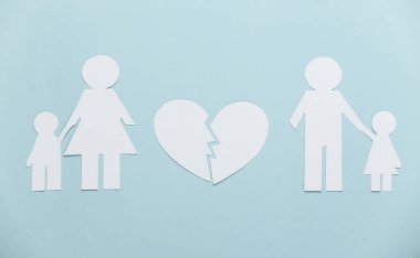 Dağılmış aile, boşanma. Kağıt aileyi böldü, kırık kalp mavi arka planda