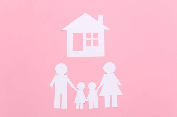 ピンクのパステルを背景に家と紙の幸せな家族 — ストック写真