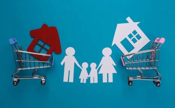 Família Papel Juntos Carrinhos Compras Com Casa Fundo Azul Conceito — Fotografia de Stock