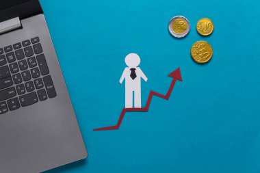 Dizüstü bilgisayar, kağıt işi adamı bozuk paralarla büyüme okunda. Mavi arka plan. Finansal ve sosyal başarının sembolü, ilerlemeye giden merdiven. Kariyer basamağı.