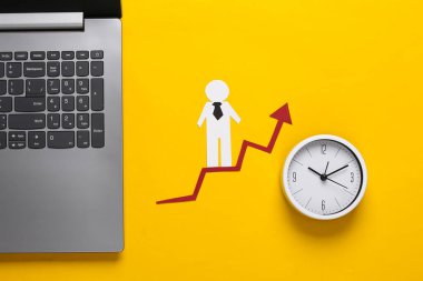 Dizüstü bilgisayar, kağıt işi adamı büyüme oku, saat. Sarı arka plan. Finansal ve sosyal başarının sembolü, ilerlemeye giden merdiven. Kariyer zamanı..