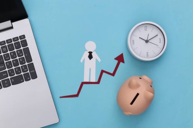 Dizüstü bilgisayar, kumbara, saat ve kağıt adam büyüme okunda. Mavi arka plan. Finansal ve sosyal başarının sembolü, ilerlemeye giden merdiven. Kariyer basamağı.