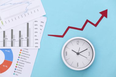 Yukarı doğru büyüyen ok, grafikler ve grafikler, mavi arkaplandaki saat. Ekonomik başarı. Üst görünüm