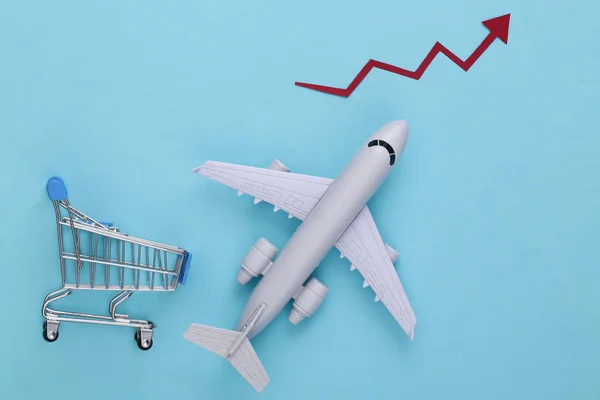 Increased international shipping. Shopping trolley and plane with growth arrow on a blue background
