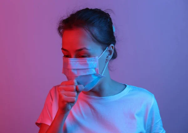 Symptoms of the flu. Woman in medical mask coughs. Red blue neon gradient light. Covid-19.