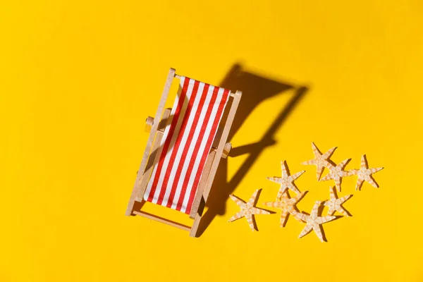 노란색 배경에 그림자가 해변용 의자와 불가사리 햇빛이요 해변의 리조트 위에서 — 스톡 사진