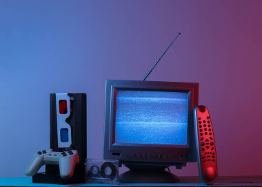Retro medya, eğlence 80 'ler. Anten, eski moda TV alıcısı, anaglyph gözlükleri, saat, ses ve video kaset, oyun platformu, pembe mavi ışıklı uzaktan kumanda. Retro dalga