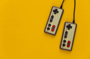 Video oyunu oyun pedleri. Oyun konsepti. Sarı arka planda iki retro joystick.