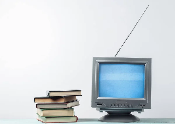 Antenna老式复古电视接收机和白墙背景书籍堆栈 — 图库照片
