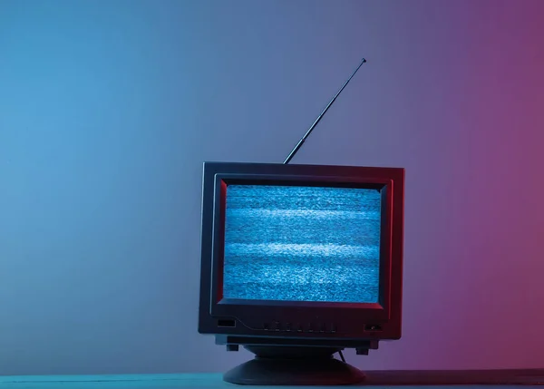Mini Retro TV anten alıcısı. Eski moda TV seti. Pembe mavi eğimli neon ışığı. Televizyon gürültüsü, sinyal yok. 80 'lerin retro dalgası