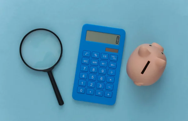 Calculadora Com Lupa Porquinho Fundo Azul Vista Superior — Fotografia de Stock