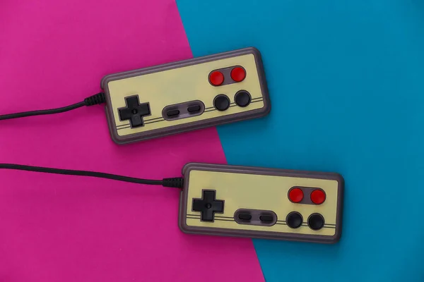 Video game Gamepads. Gaming concept. Top view two retro joysticks on pink blue background.