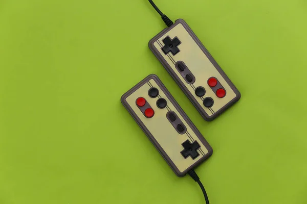 Video game Gamepads. Gaming concept. Top view two retro joysticks on green background.