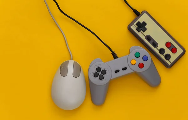 Retro joysticks and pc mouse on a yellow background. Retro gaming, gaming devices, gadgets
