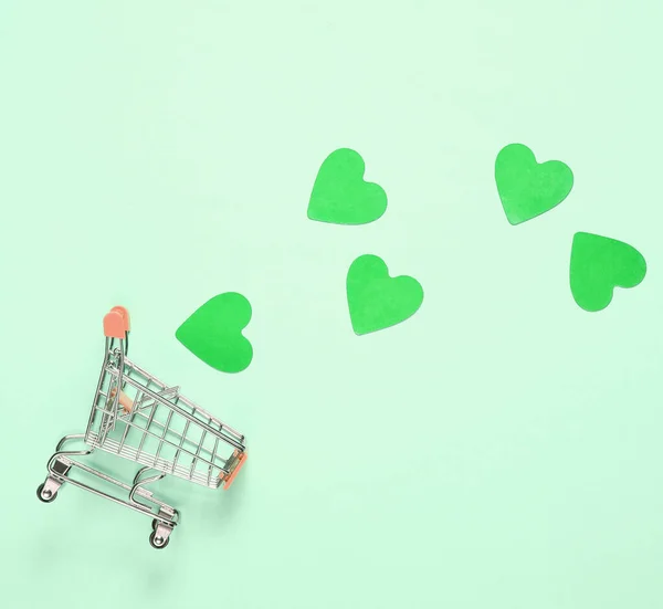 Mini Alışveriş Arabası Yeşil Arka Planda Dekoratif Kalpler Üst Manzara — Stok fotoğraf