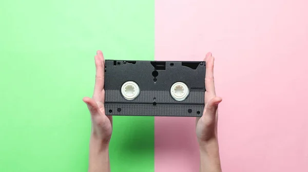 Las Manos Femeninas Sostienen Cassette Vídeo Sobre Fondo Pastel Verde —  Fotos de Stock