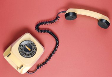 Kırmızı arka planda cep telefonu olan geri dönüşlü telefon. Üst görünüm