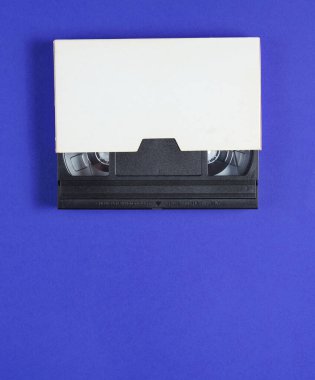 Mavi arka plandaki bir evrak çantasındaki kaset. Popüler kültür nitelikleri, minimalizm. Üst görünüm