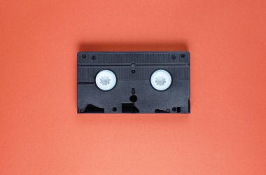 Popüler kültür 80 'leri, kırmızı arka planda video kasedini özetliyor. Üst görünüm