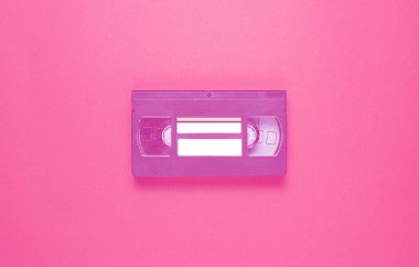 Popüler kültür 80 'leri, kırmızı arka planda video kasedini özetliyor. Üst görünüm