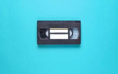 Popüler kültür 80 'leri, mavi arka plandaki video kasedini özetliyor. Üst görünüm