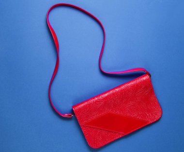 Mavi arka planda Retro tarzı kırmızı deri çanta. Üst görünüm