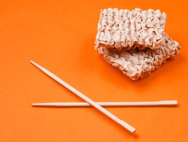 Çiğ erişte ve portakal arka planda Çin yemek çubukları, minimalizm..