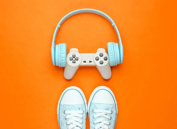 Conceito Jogador Gamepad Com Fones Ouvido Tênis Fundo Laranja Vista — Fotografia de Stock