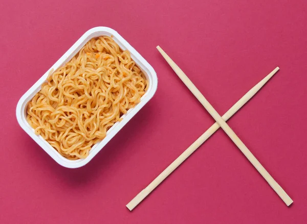 方便面和中国筷子的红色背景 简约主义 顶部视图 — 图库照片