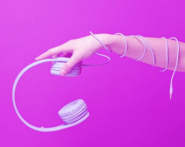 Elle sarılmış kablo mavi kulaklık taşıyor. Duotone etkisi