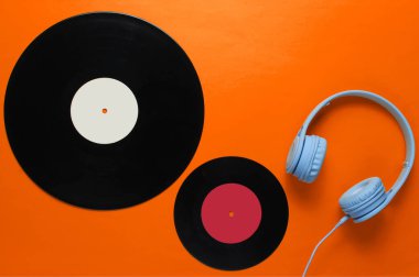 Müzik aşığı. Kulaklıklar, turuncu arka planda IP kayıtları. Retro kültür. Düz yatıyordu. Üst görünüm