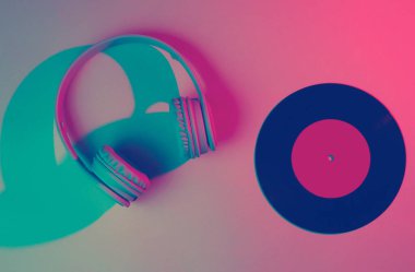 Plastik plaklı kulaklıklar. 80 'ler. Retro dalga, neon ışık, morötesi. Üst görünüm, minimalizm